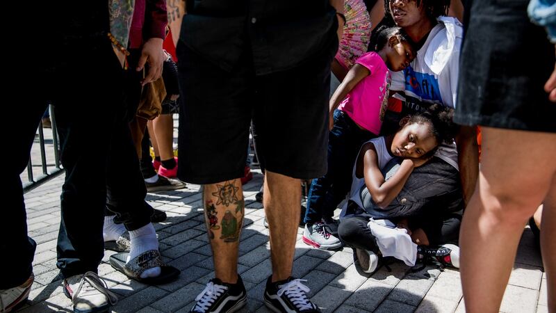 Rico Hendrix (19) sits alongside his sisters SaRiah (8) and Ceecy (3) at the front of the line of fans at a memorial and viewing for rapper XXXTentacion. Photograph: Scott McIntyre/The New York Times