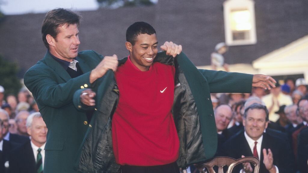 Nick Faldo puts the green jacket on Tiger Woods after the American’s record-breaking win at the 1997 US Masters. Photo: Getty Images