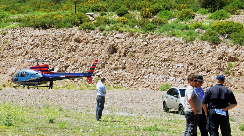 Policemen stand near a police helicopter after a helicopter carrying a team recording for a reality show of US MTV crashed. Photograph: AFP