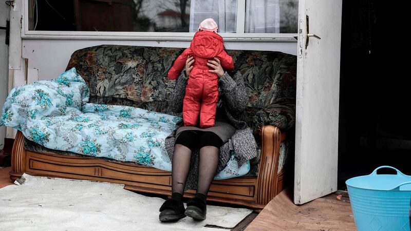A woman holds a baby in a camp of the Roma community that was attacked after a false video circulated on social media. Photograph: Kenzo Tribouillard/AFP