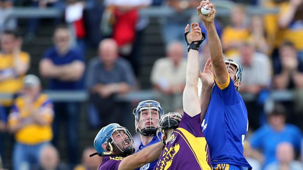 Brendan Bugler wins a high ball while under pressure from Garrett Sinnott and PJ Nolan of Wexford at Cusack Park last week. Photo: Cathal Noonan/Inpho