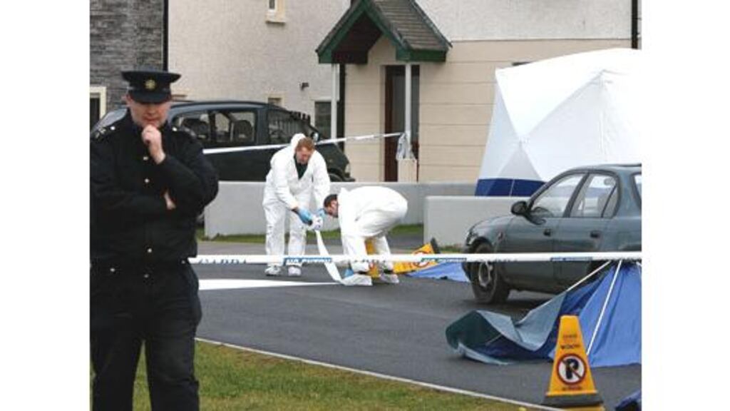 Forensic experts examine the scene in a housing estate in Ennis,
Co Clare, where a man was fatally stabbed early on Sunday
morning.