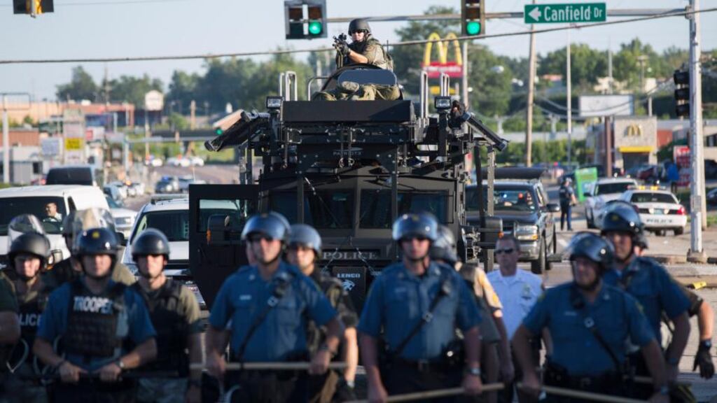 Riot police stand on guard as demonstrators protest against the shooting dead of teenager Michael Brown in Ferguson, Missouri, on Wednesday. A witness in the case told local media that Brown had raised his arms to police to show that he was unarmed before being killed. Photograph: Mario Anzuoni/Reuters