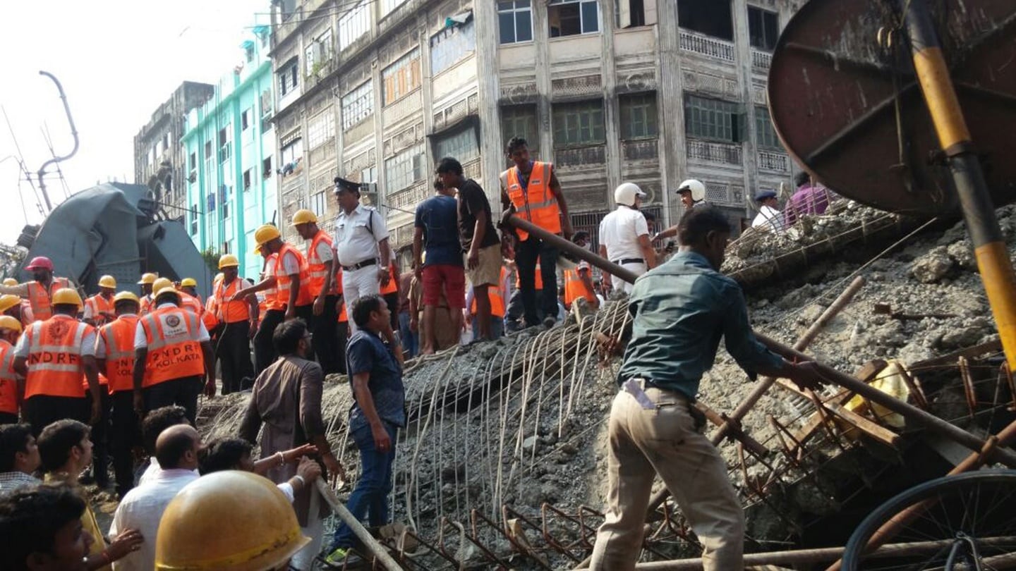 Locals and rescue workers clear the rubbles of a partially collapsed overpass in Kolkata. Photograph: Bikas Das/AP