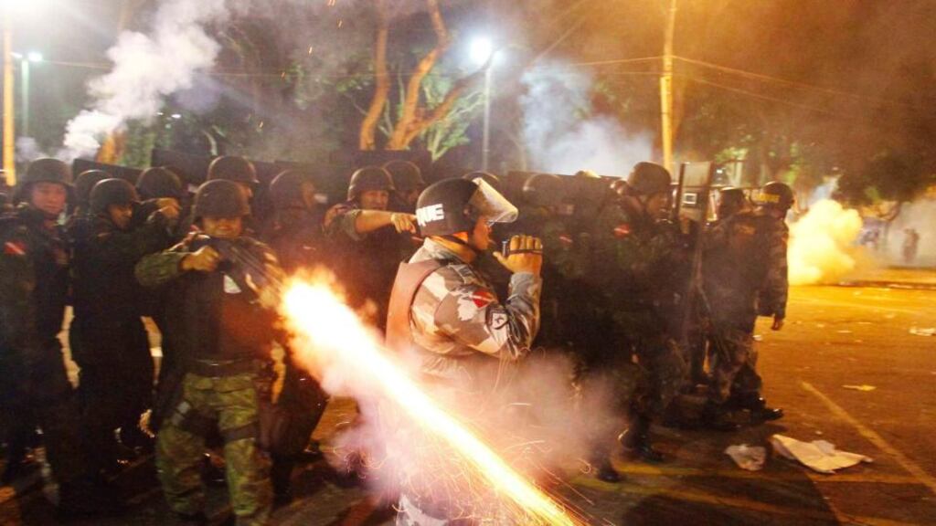 A riot policeman fires his weapon while confronting stone-throwing demonstrators during an anti-government protest in Belem, at the mouth of the Amazon river, in Brazil last night. Photograph: Ney Macondes/Reuters