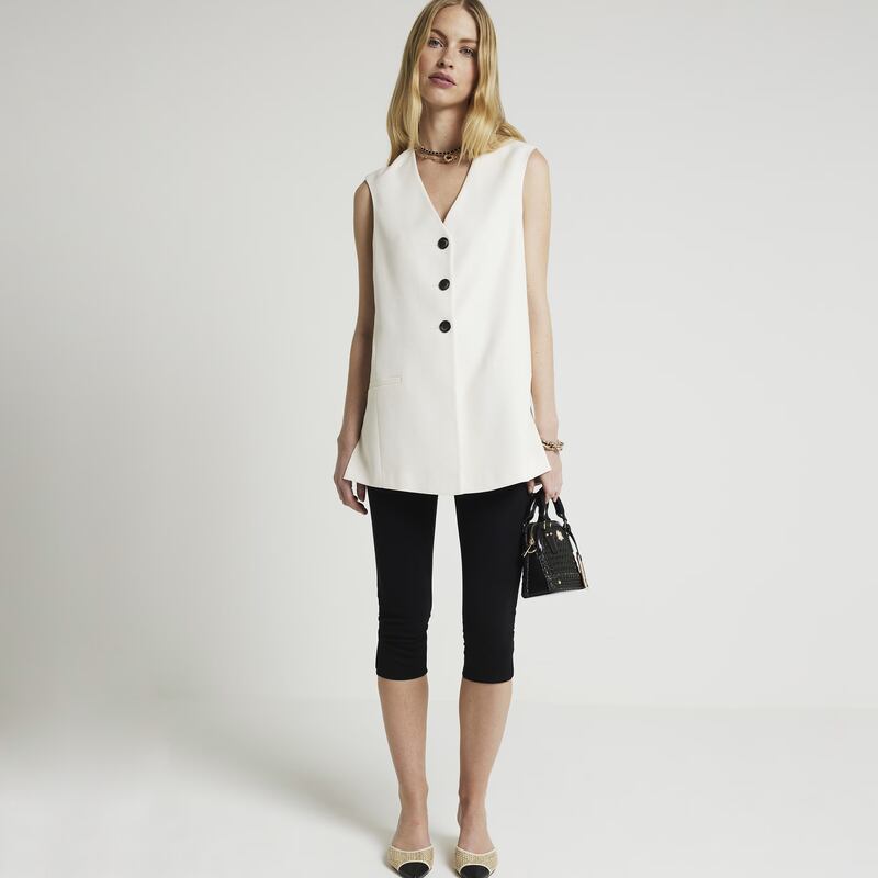 Black cropped leggings, €23; cream longline waistcoat, €64; both at River Island