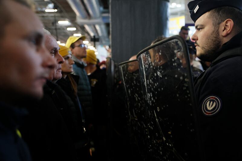 French farmers face French police officers during the protest at the Porte Versailles exhibition centre. Photograph: Kiran Ridley/AFP