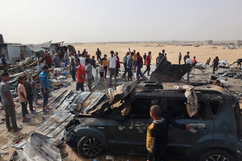 Palestinians in Rafah: the camp was a smoking wreckage of tents, twisted metal and charred belongings. Photograph: Eyad Baba/AFP