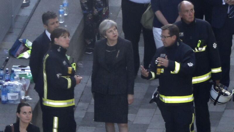 British prime minister Theresa May meeets firefighters as she visits the remains of Grenfell TowerPhotograph: Tolga Akmen/AFP/Getty Images.