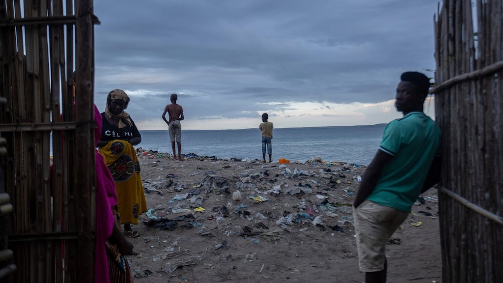 Men keep an eye on the sea at the port of Paquitequete in Pemba boats have arrived carrying people displaced from the coasts of Palma and Afungi after suffering attacks by Islamist militants. Photograph: Alfredo Zuniga/AFP/Getty Images)