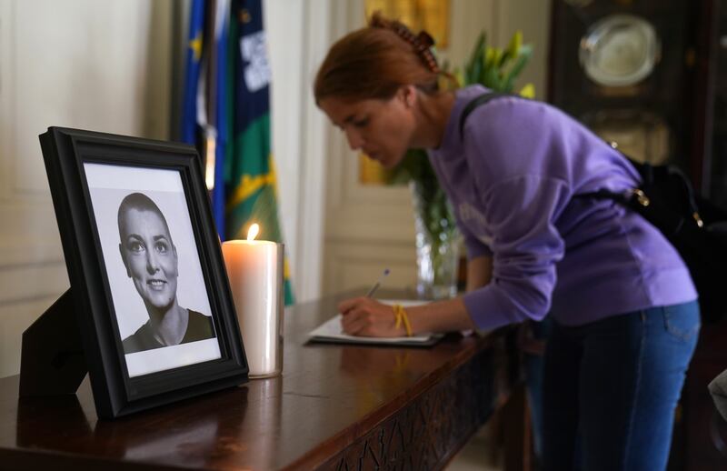 A person signs a book of condolence for Sinead O'Connor at the Mansion House in Dublin, after her death at the age of 56. Photograph: Brian Lawless/PA Wire