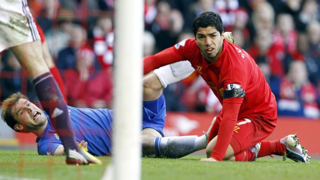 Luis Suárez (right) and Branislav Ivanovic on the ground after the Liverpool player bit his opponent during a Premier League match on Sunday. Photograph: Peter Byrne/PA