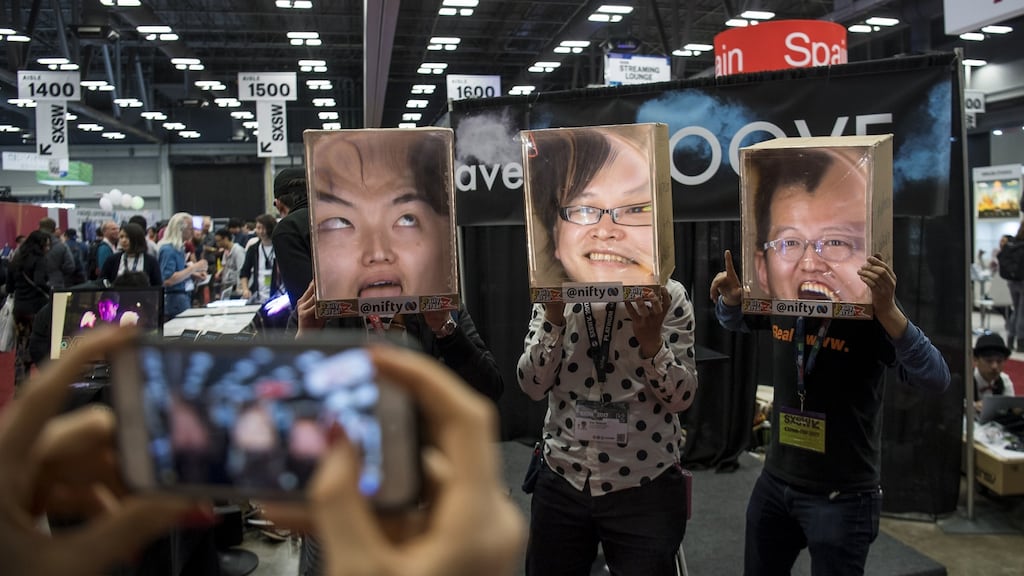 Attendees wear cardboard “faceboxes” at the SXSW interactive festival in Austin. Photographer: David Paul Morris/Bloomberg