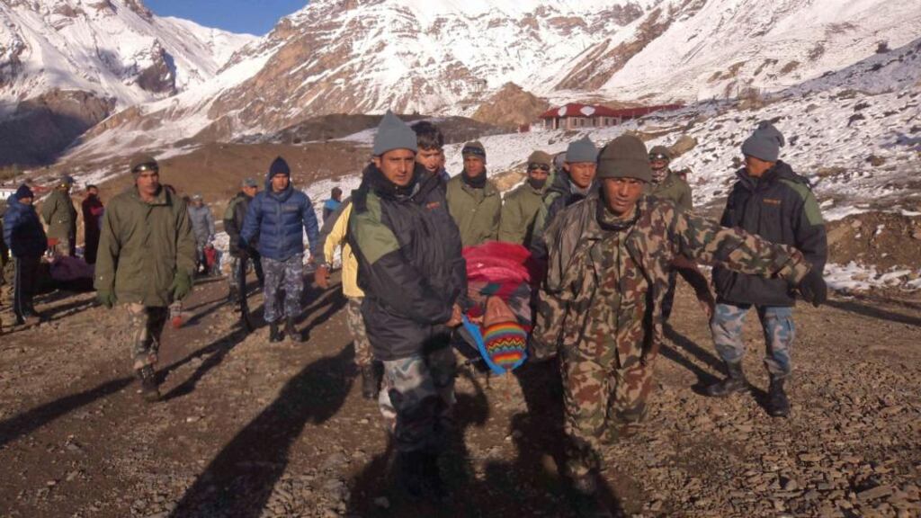 Emergency responders carry a victim of an avalanche away from the area near Thorang-La in the Annapurna region of Nepal. A blizzard and avalanche in Nepal’s Himalayas climbing region have killed at least 20 people.