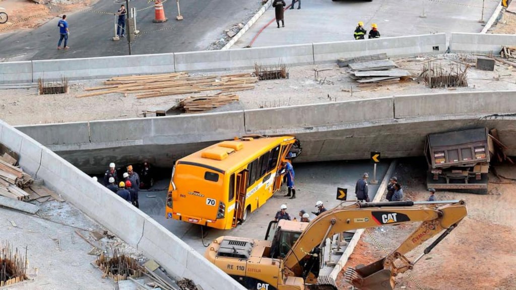 Rescue workers try to reach vehicles trapped underneath the bridge that collapsed while under construction in Belo Horizonte. Photograph: Carlos Greco-DYN/Reuters