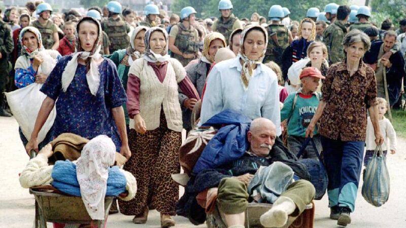 Bosnian refugees from the fallen eastern Bosnian enclave of Srebrenica walk from the United Nations base at Potocari to transport across front lines July 13, 1995. Photograph:  Nick Sharp/Reuters
