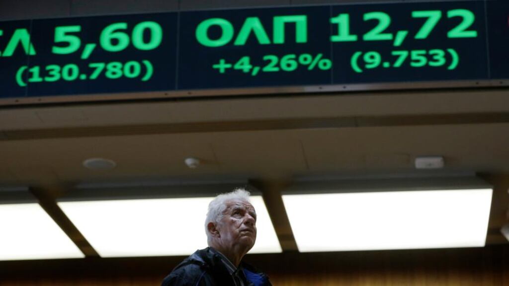 An elderly man looks at rising stocks in green at the Stock Exchange in Athens. Photograph: AP Photo/Thanassis Stavrakis