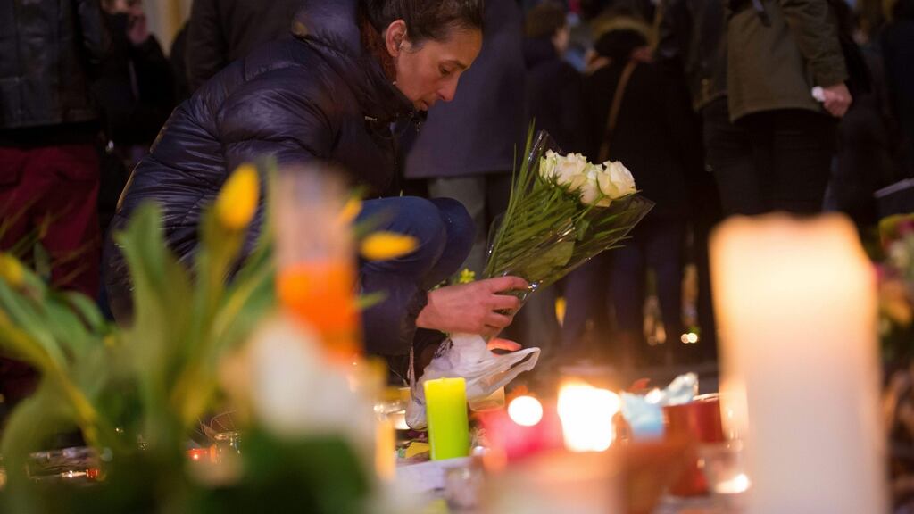 A woman places flowers at a makeshift memorial as hundreds of people gather in front of Brussel’s Stock Exchange on Thursday. Photograph: Philippe Huguen/AFP/Getty Images