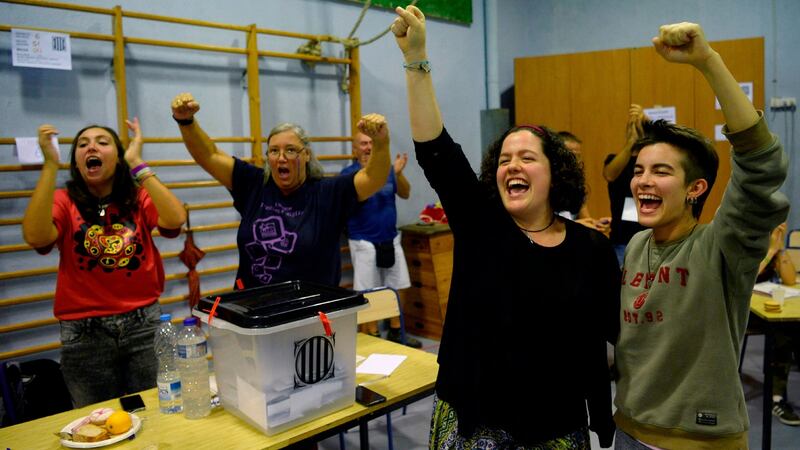 People celebrate at a polling station in Barcelona on Sunday. Photograph: Josep Lago/AFP/Getty Images