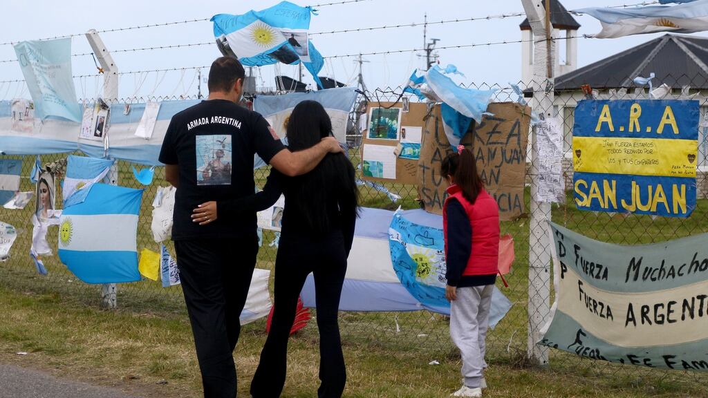 A family visits the a makeshift tribute made with flags and notes to the 44 crew members of the missing submarine at the Argentina Navy base at Mar del Plata. Photograph: Arduin Mauricio/EPA
