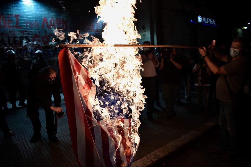 Greek demonstrators burn a US flag during a protest against the visit to Greece of then US secretary of state Mike Pompeo, in Thessaloniki, September 2020, after Pompeo said the US would use its influence in the region to try to ease a volatile dispute between Nato allies Greece and Turkey over energy rights. Photograph: Sakis Mitrolidis/AFP via Getty