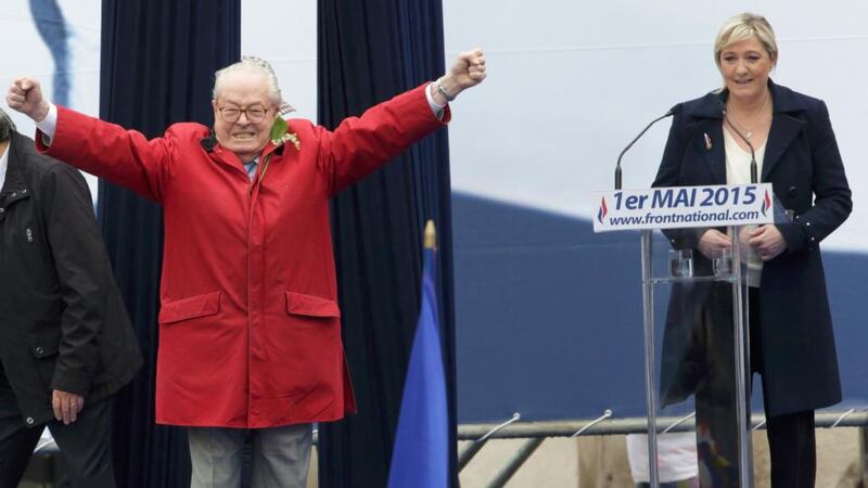 France’s far-right National Front political party leader Marine Le Pen (right) watches as her father Jean-Marie Le Pen, party founder and honorary president, reacts on the podium at their May Day tribute to Joan of Arc. Photograph: Philippe Wojazer/Reuters