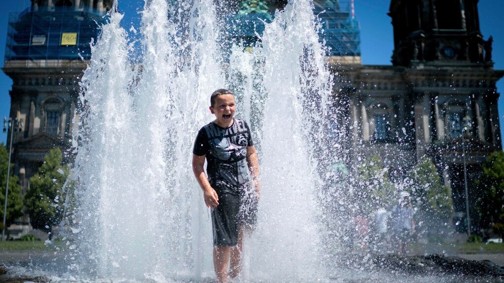 A boy cools down a fountain in Berlin, Germany during the heatwave. Photogtaph: Kay Nietfeld/dpa/AP