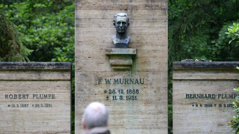 A man looks at a crypt of the Murnau and Plumpe families in Stahnsdorf, Germany. Grave robbers have stolen from a crypt the head of German expressionist cinema great Friedrich Wilhelm Murnau, director of the silent-film vampire classic ‘Nosferatu’. Photograph: Ralf Hirschberger/AFP /Getty Images