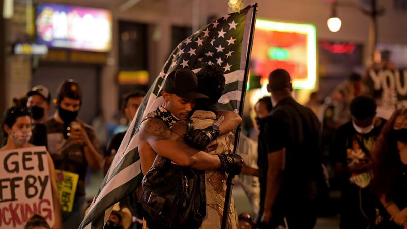 Two men embrace next to a makeshift memorial in honour of the victims of police brutality, during a demonstration against racism, in Hollywood, California on Sunday. Photograph: Agustin Paullier/AFP via Getty Images