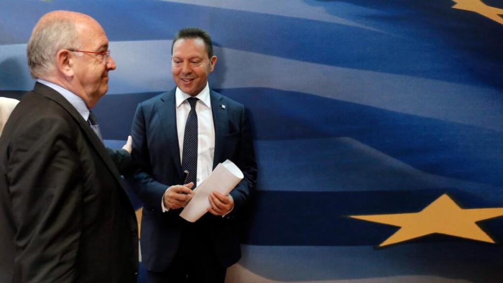 Greek finance minister Yannis Stournaras (R) and European Commissioner for Competition Policy Joaquin Almunia (L) leave after a press conference in Athens yesterday. Photograph: EPA/Yannis Kolesidis