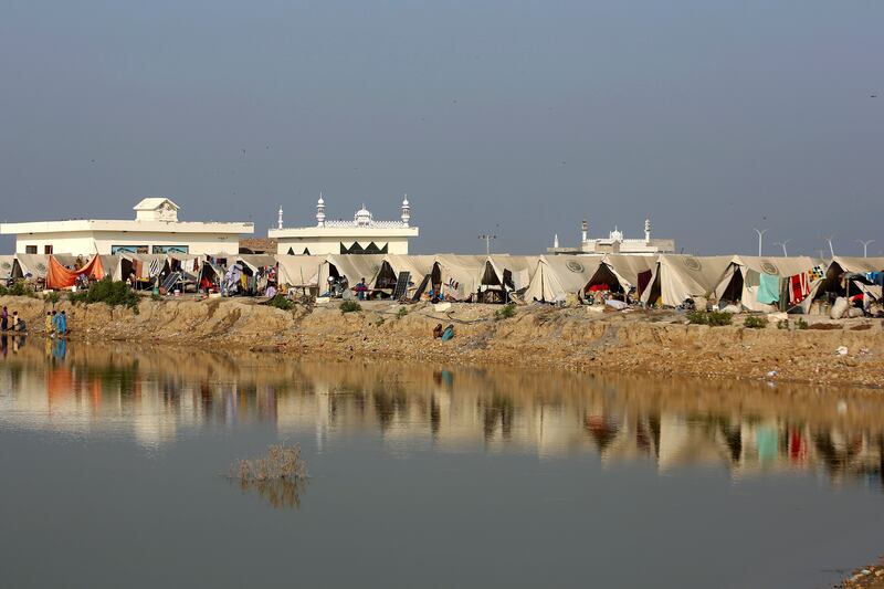People take refuge in a relief camp set up on a higher ground surrounded by floodwaters in Pakistan. Photograph: Fareed Khan/AP