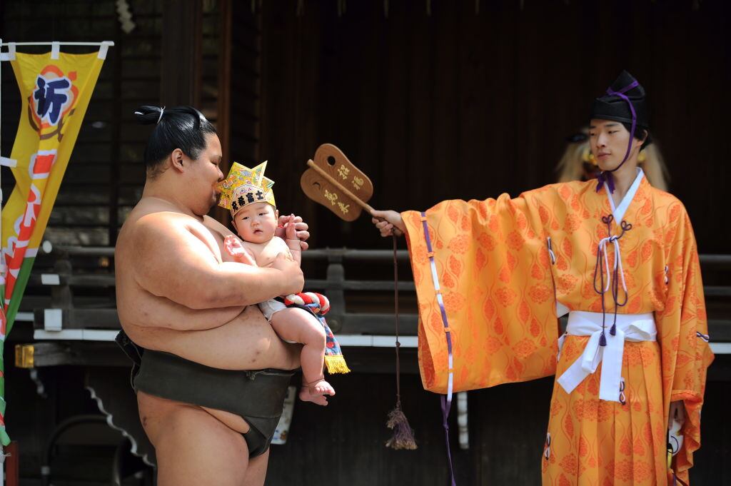 A baby is carried by a sumo wrestler in Tokyo in a 400-year-old traditional event. Photograph: David Mareuil/ Getty Images