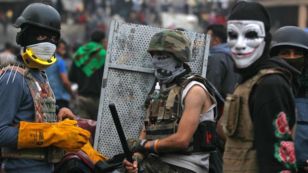 Iraqi demonstrators wearing protective gear rest amid clashes with security forces in Baghdad on Wednesday. Photograph: Ahmad Al-Rubaye/AFP via Getty Images