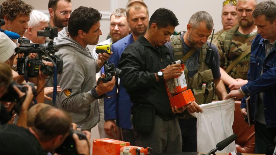 A Malaysian expert (C) examines a black box belonging to Malaysia Airlines flight MH17 during its handover from pro-Russian separatists, in Donetsk early today. Photograph:Maxim Zmeyev/Reuters