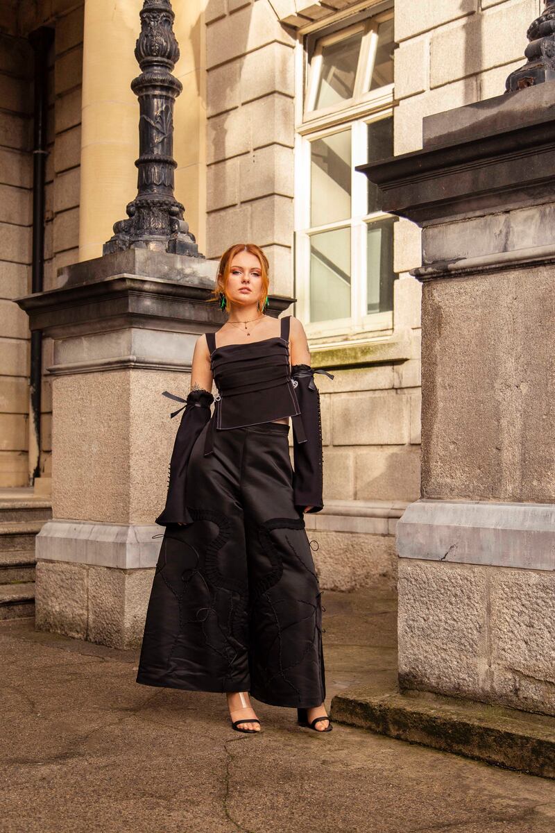 Pleated backless top with crystal embellishment €110 and laser cut detachable sleeves €90 both by Abigail Joy Heaslip, wide leg embellished satin trousers €950 by Sadhbh Dwyer, gold plated locket €75 by Aliquo, azure cluster earrings €50 by David O Malley, Elytra earrings €80 by David O Malley, leather and perspex mules, model's own. Photograph: Mark Hill