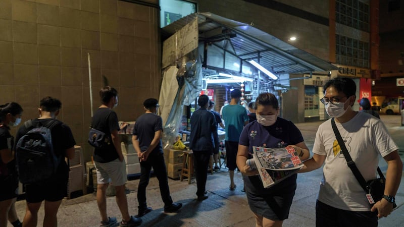 People queue up to buy fresh copies of the Apple Daily newspaper at a stall in the Mongkok district of Hong Kong early on Tuesday. Photograph: Yan Zhao/ AFP/Getty Images
