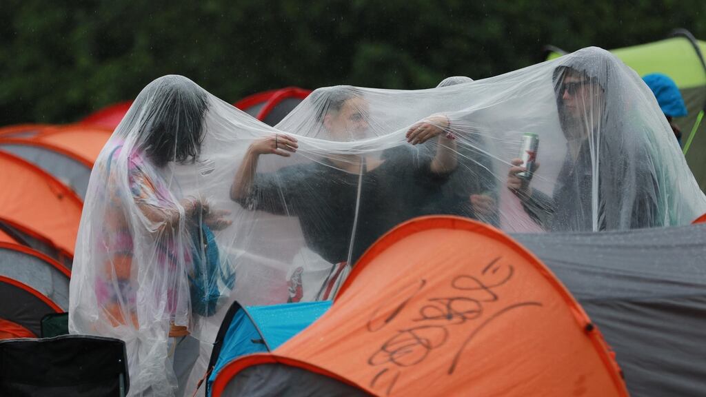 Festivalgoers improvise during a deluge at Ballinlough Castle, Co Westmeath. Photograph: Nick Bradshaw