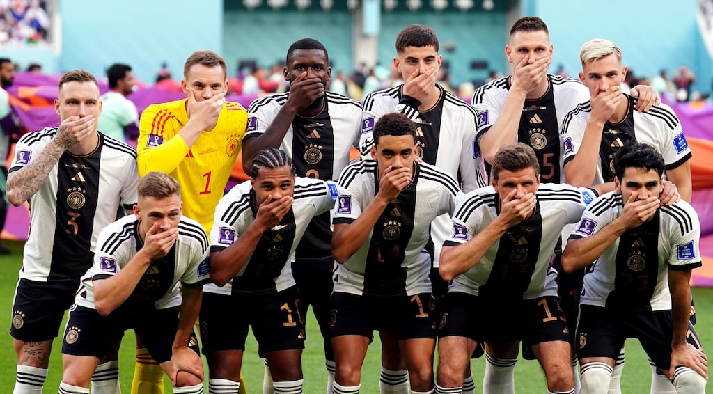 German players cover their mouths as they pose for a team photograph against Japan. Photograph: Mike Egerton/PA Wire