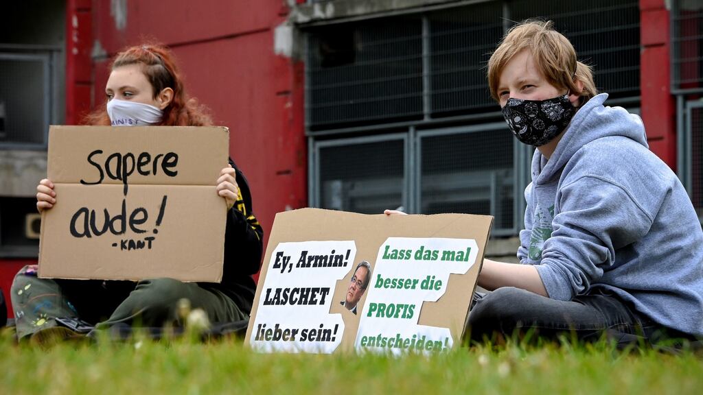 Students wearing protective face masks show banners reading ‘Better let the professionals decide!’, as they protest against the opening of schools, in Dusseldorf, Germany. Photograph: EPA/Sascha Steinbach