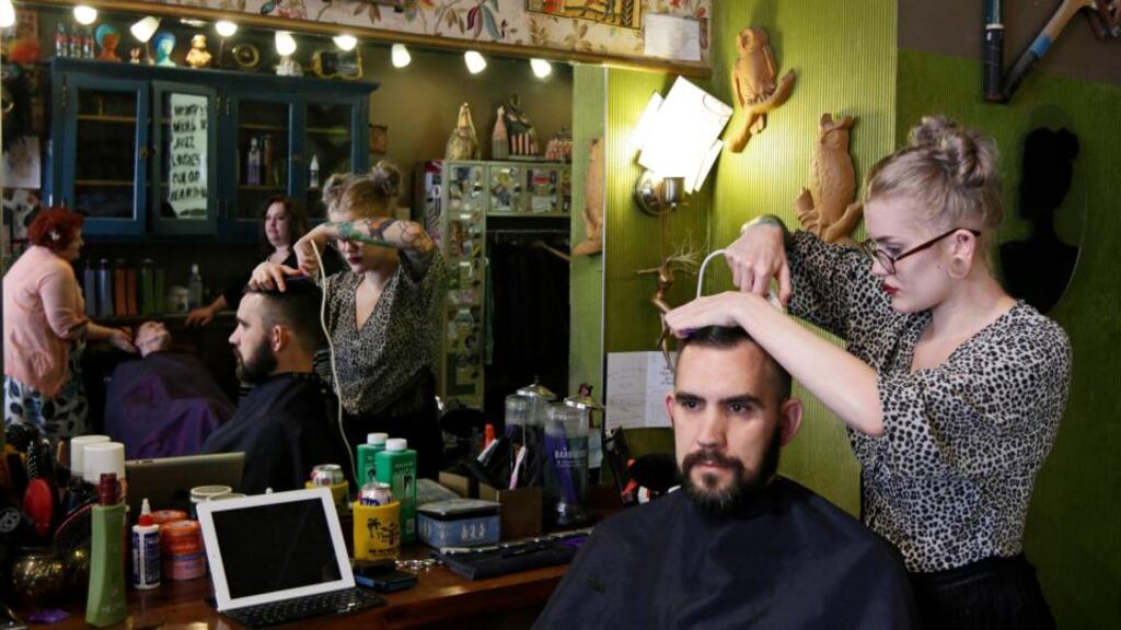 Jenna Morris trims Nick Bonora’s hair at Bernadette’s Barbershop in  Lafayette, Indiana.  The store is one of several that display a sticker stating: “This business serves everyone.” Photograph: Nate Chute/Reuters