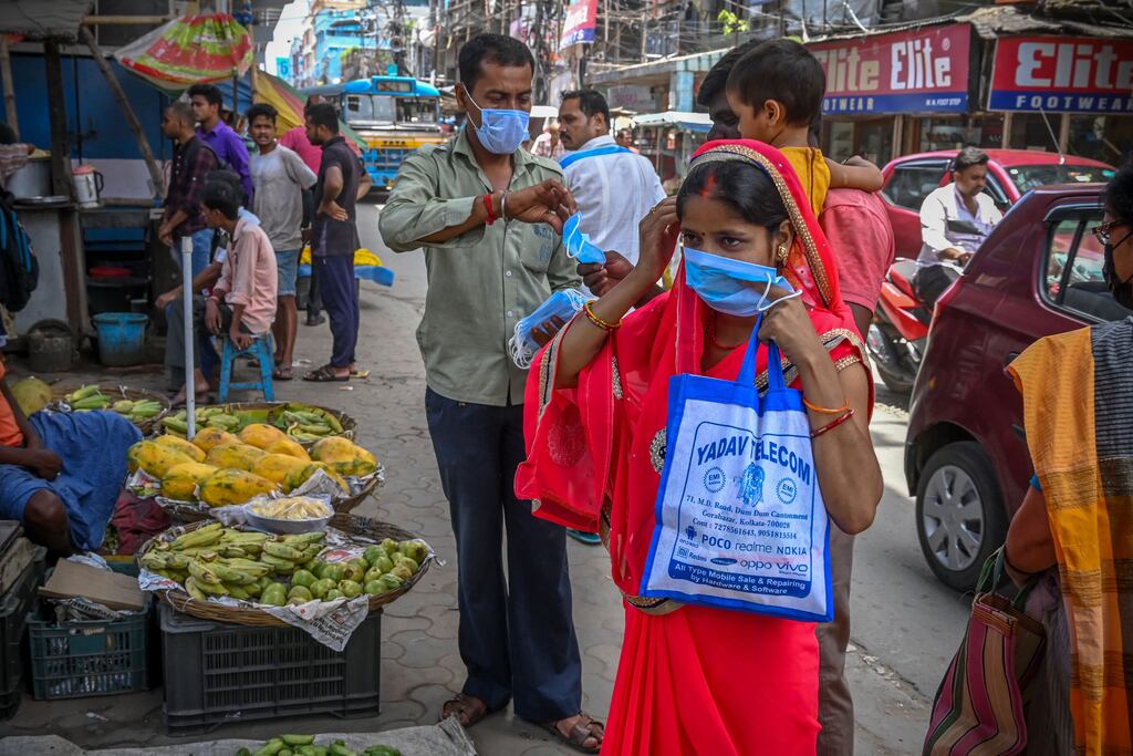Health workers distribute face masks to curb the spread of Covid-19 in Kolkata. Photograph: DIBYANGSHU SARKAR/AFP via Getty Images