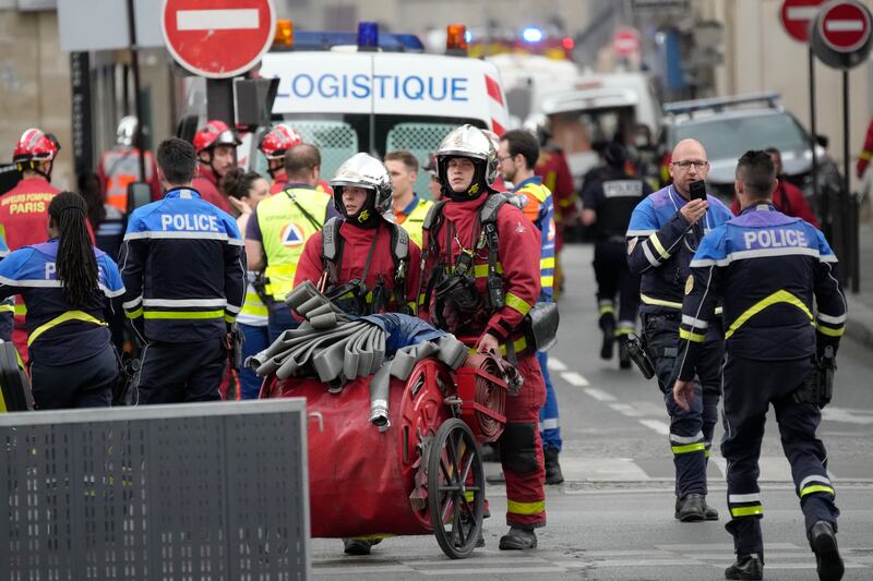 Police officers and rescue workers work at the scene (Christophe Ena/AP)