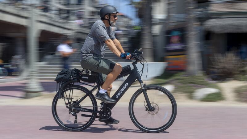 A man rides an electric bicycle nin Huntington Beach, California, in April. Photograph: Paul Bersebach/Orange County Register via Getty Images