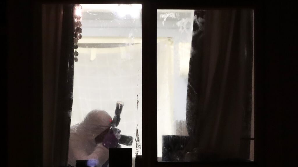 A PSNI forensic officer the apartment building on Kinnaird Close, Belfast, after the bodies were found this afternoon. Photograph: PA