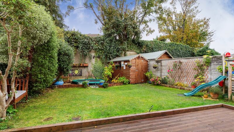 The modest-sized rear garden has a deck, lawn and a wood-chip play are