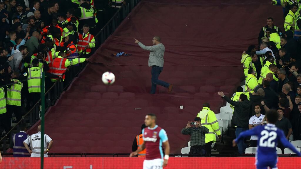 A Chelsea fan gets past the police line and walks over to West Ham United fans during the EFL Cup fourth round match between West Ham and Chelsea at The London Stadium. Photo: Clive Rose/Getty Images