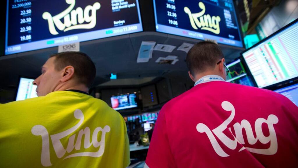 Traders wearing King Digital Entertainment T-shirts await the opening bell on the floor of the New York Stock Exchange. Photographer: Jin Lee/Bloomberg