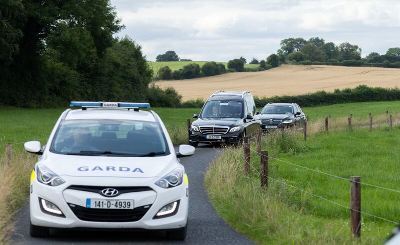 A Garda car and hearse leaving the site at which a helicopter crashed in Joristown, Co Meath. Photograph: Colin Keegan, Collins Dublin
