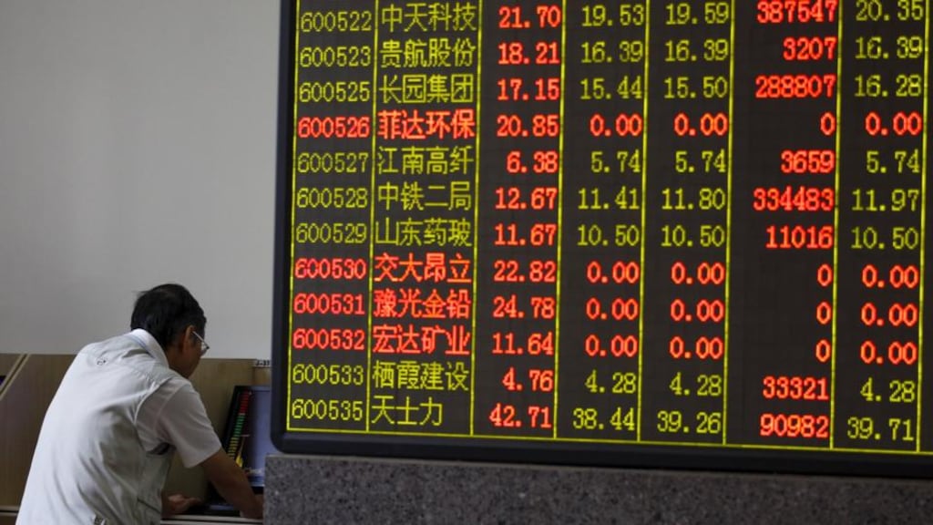 An investor looks at a computer screen showing stock information at a brokerage house in Kunming, Yunnan province, China. Photogrpah: Wong Campion/Reuters
