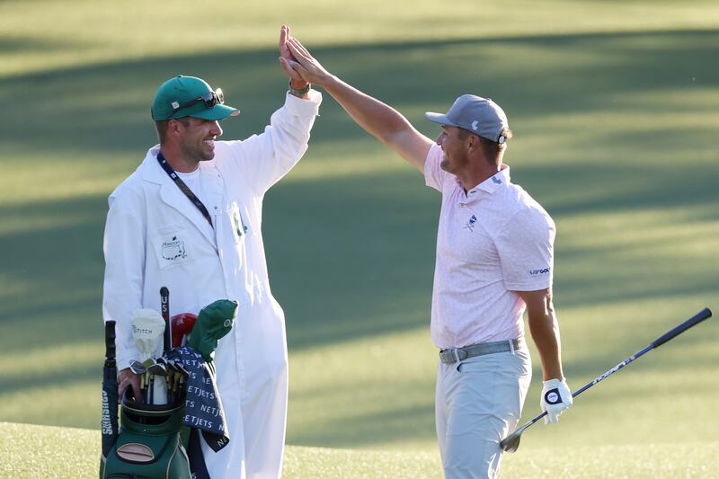 Bryson DeChambeau of the United States and caddie Greg Bodine celebrate after chipping in for birdie on the 18th. Photograph: Jamie Squire/Getty Images